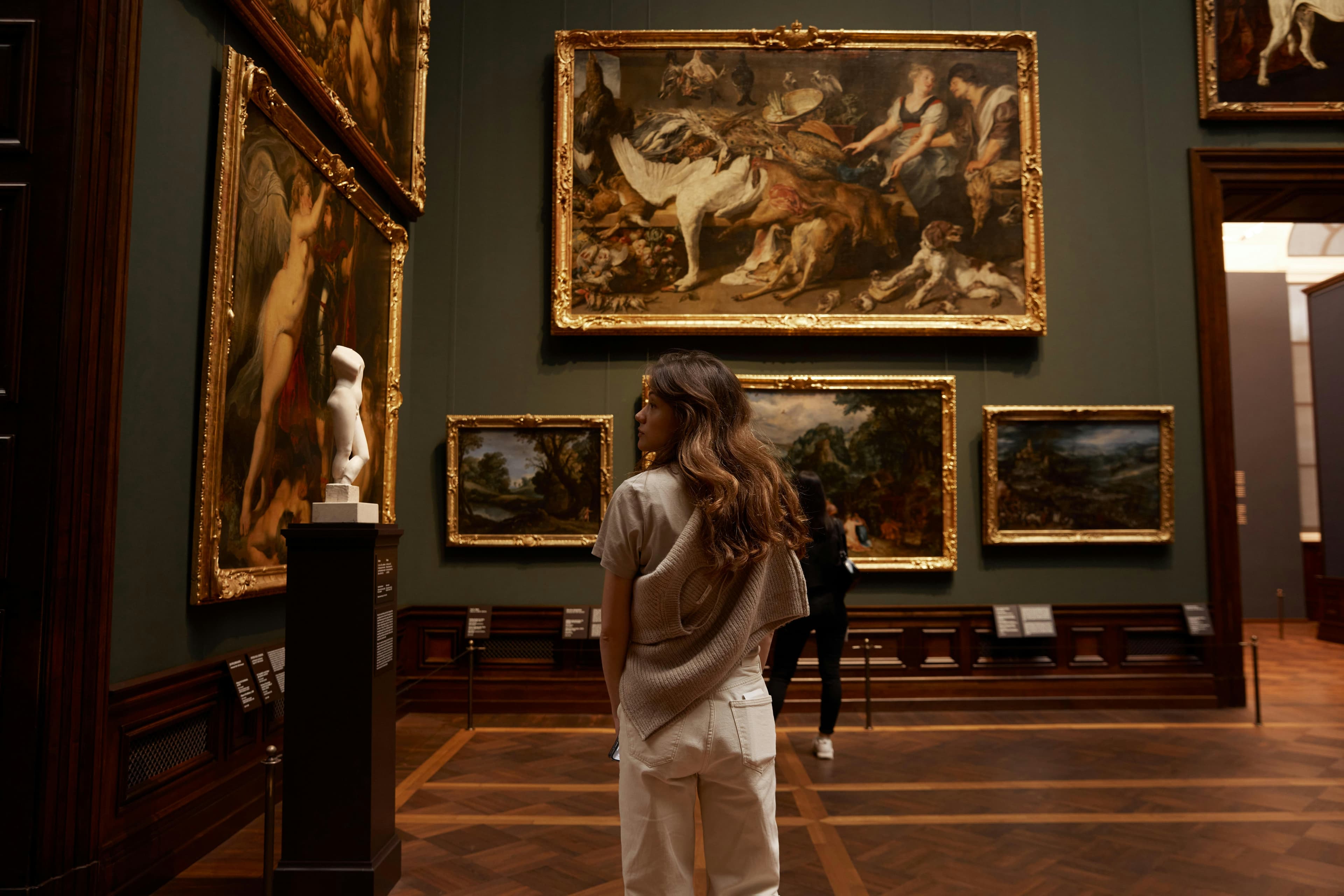 Kvinde der betragter malerier på væggen i et kunstmuseum