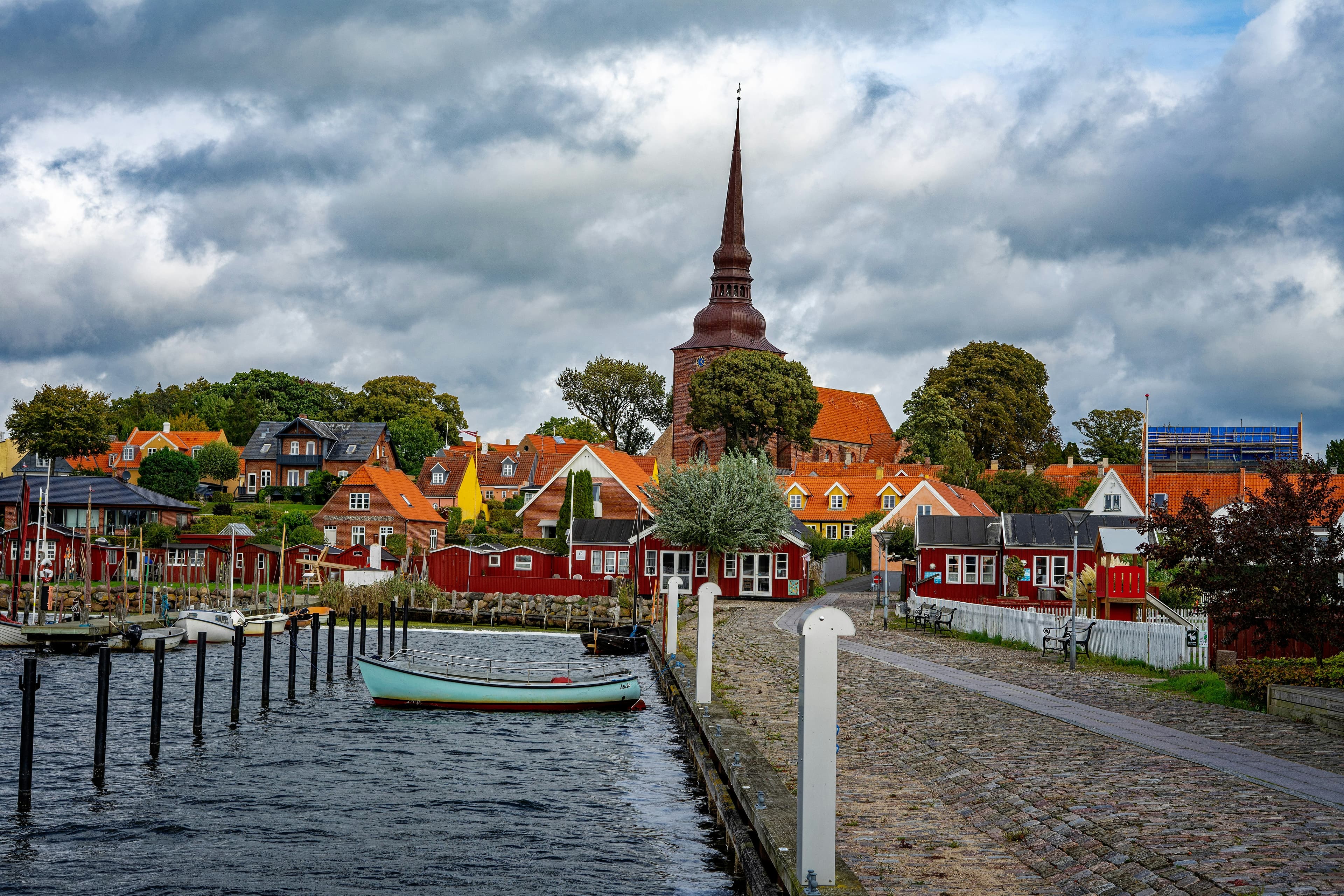 Dansk købstad med kirketårn set hen over havnen